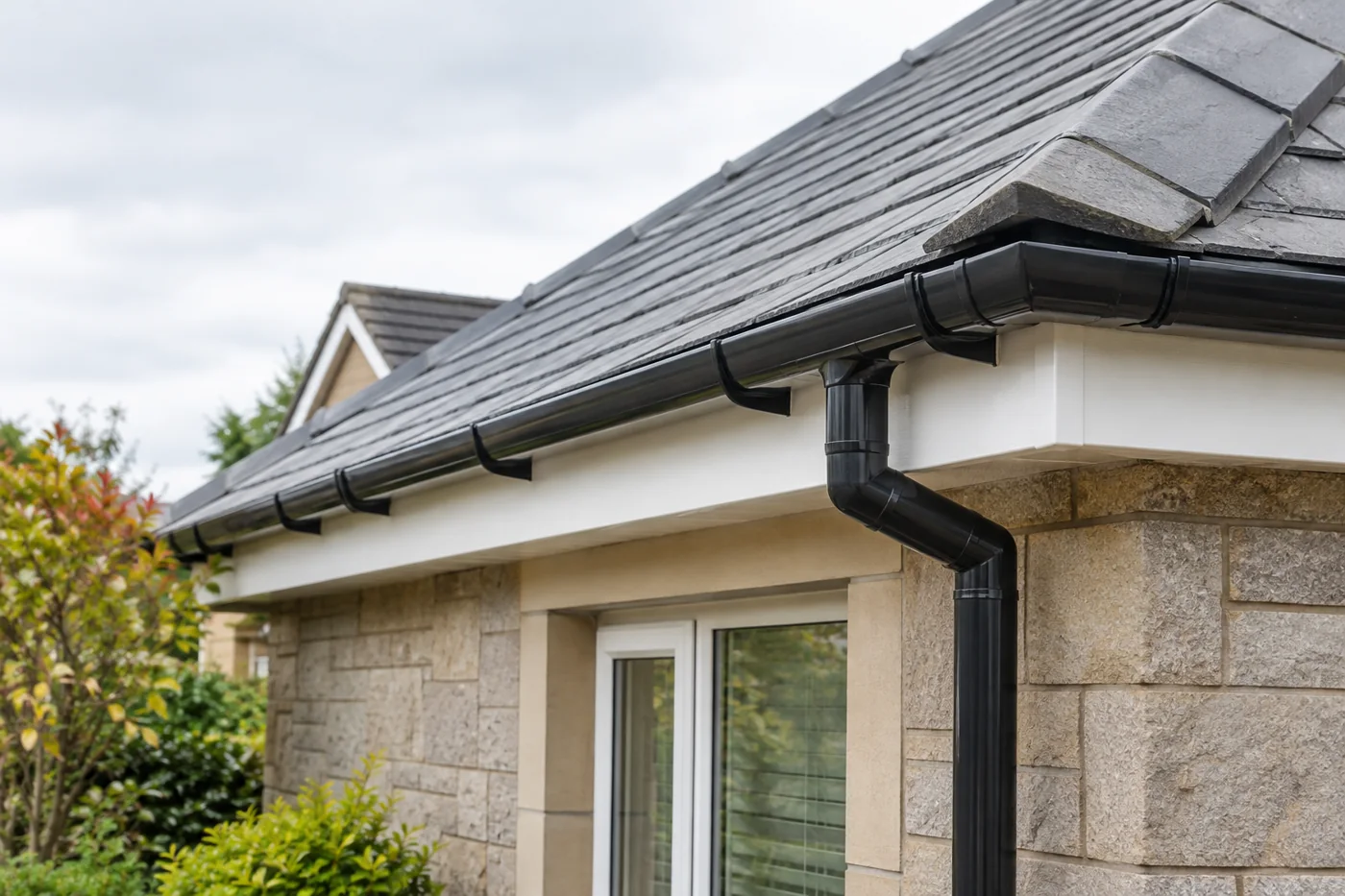 Guttering, fascia and downpipe beneath domestic roof eaves